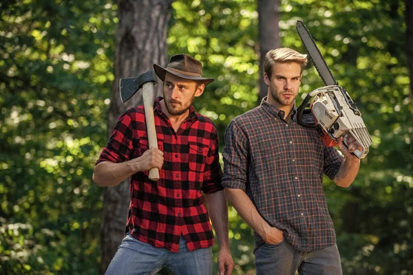 leisure time together. summer or spring activity. man farmers relax in forest. rangers use equipment. Lumberjack with chainsaw and ax. Harvest firewood. hiking in deep wood. forest care at vacation