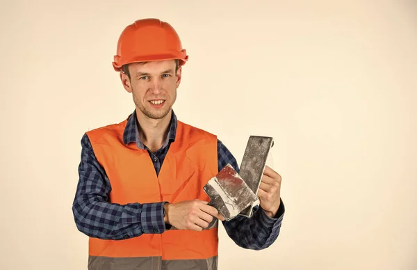 Bouwen en bouwen. bekwame architect reparatie en reparatie. loopbaan als ingenieur. gereedschap voor reparatie. Een jongeman met een hoed. De bouwer gebruikt spatels. professionele reparateur in helm. Toekomstig beroep — Stockfoto