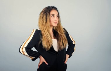 Zarif ve atletik parçaları karıştırıyorum. Spor kıyafetleri podyumlarda kural koyuyor. Voluminous kıvrımlı saç stili. Moda kıvrımlı saç stili. Şık spor. Mavi arka planda kadın saç stili. Moda eğilimi