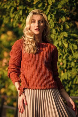 Çok güzel. Kadın güzeli. Kadınlık ve şefkat. Etek ve süveter giyen kız. Pileli trend. Düşen yapraklarla güneşli bir gün. Sonbahar moda sezonu. Sonbahar kadını dışarıda. Kız parkta yürüyor.