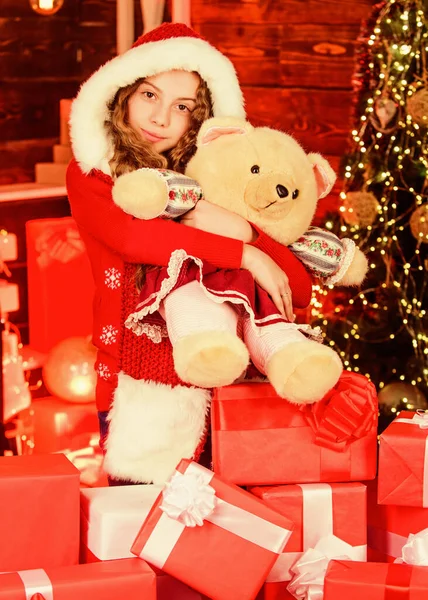 クリスマスシーズンだ。新年明けましておめでとう。現在の箱とおもちゃのクマのサンタの子供。冬の買い物販売。クリスマスツリーの幸せな女の子。喜びで家を飾る。クリスマス気分だ。ご家族のお祝い — ストック写真