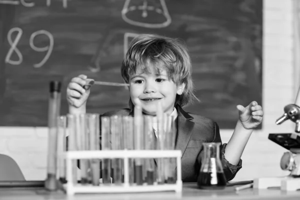 O miúdo estuda química. Biotecnologia e farmácia. Aluno génio. Conceito de educação. Wunderkind a fazer experiências com química. Cientista talentoso. Tubos de teste Boy química líquidos. Análise química — Fotografia de Stock