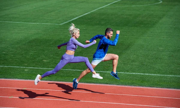 O desporto é a nossa vida. corredores em pista de corrida. desafio e concorrência. Resistência. resistência à energia. caber pessoas desportivas pulando. homem e mulher esporte treinador correr. fitness casal formação ao ar livre — Fotografia de Stock