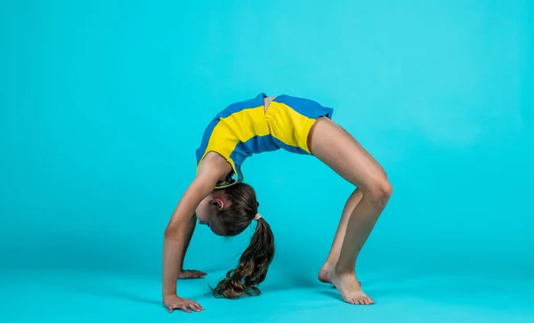 Счастливый ребенок в спортивной одежде тренировки, акробатика — стоковое фото