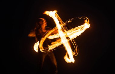 Görülmesi gereken bir olay. Seksi kadın karanlıkta sonsuz dönüşler yapar. Dönme sanatı. Yangın gösterisi. Tatil kutlaması. Gece partisi. Ateş Festivali. Eğlence ve eğlence. Bulanık efekt