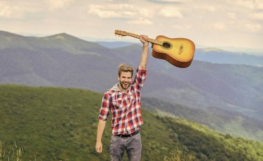 Hippi müzisyen. Yürüyüş şarkısı. Dağda gitarlı bir müzisyen. İlham verici bir müzisyen. İlham verici bir ortam. Açık havada yaz müzik festivali. Dağların sessizliği ve gitar tellerinin sesi