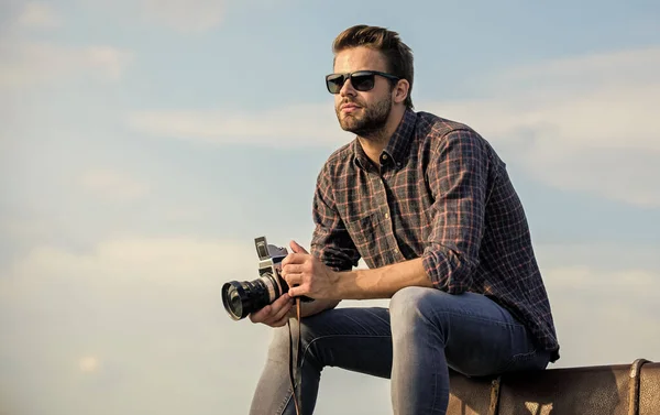 Sur le voyage. voyageur attendre la voiture. style masculin de mode. à la mode. homme sexy journaliste touristique. photographe à lunettes. homme macho avec caméra sur les bagages. capturer aventure. journaliste — Photo