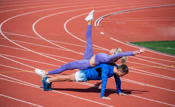 Egzersiz yaparken yukarı kaldır. Antrenman yarışması. Çekirdek kasları için kalas. Sağlık hayattır. Yardım ve destek. sportif insanlar. Erkek ve kadın spor eğitmeni. Fitness çifti birlikte çalışıyor.