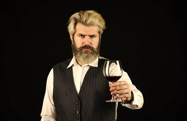 Wine bar or winery. drink degustation. Bearded businessman in elegant suit with glass of wine. Sommelier tastes expensive drink. Elegant waiter drink red wine. working in wine cellar