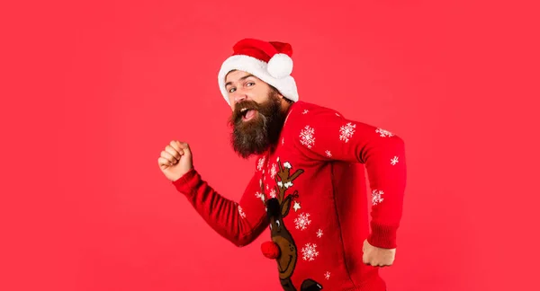 Igyekezz! érett férfi pulóverben piros háttérben. Karácsonyi ajándékokra és ajándékokra készen. Újévi vásárlási kedvezmények. Karácsonyi parti. Szakállas télapó kalapban. Ünnepeljünk! — Stock Fotó
