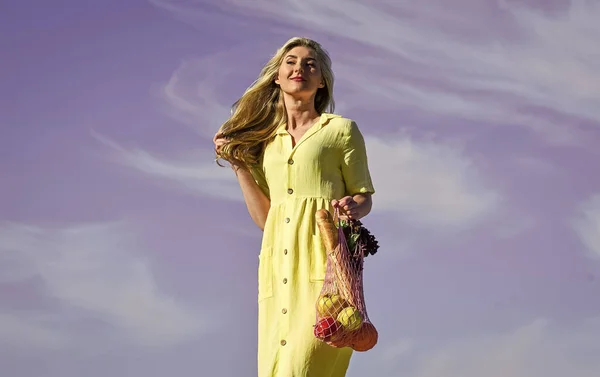 Cero residuos. Concepto libre de plástico. Bolsas eco de algodón y malla reutilizables para ir de compras. Día de verano niña fondo cielo azul. Eco consciente. Mujer llevar frutas y verduras en bolsa ecológica. Estilo de vida sostenible — Foto de Stock