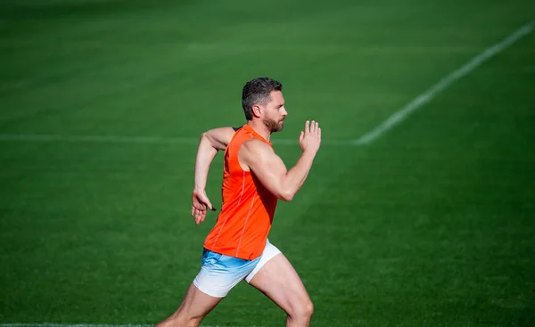 Atletische gespierde man loopt op racebaan in outdoor stadion, succes — Stockfoto