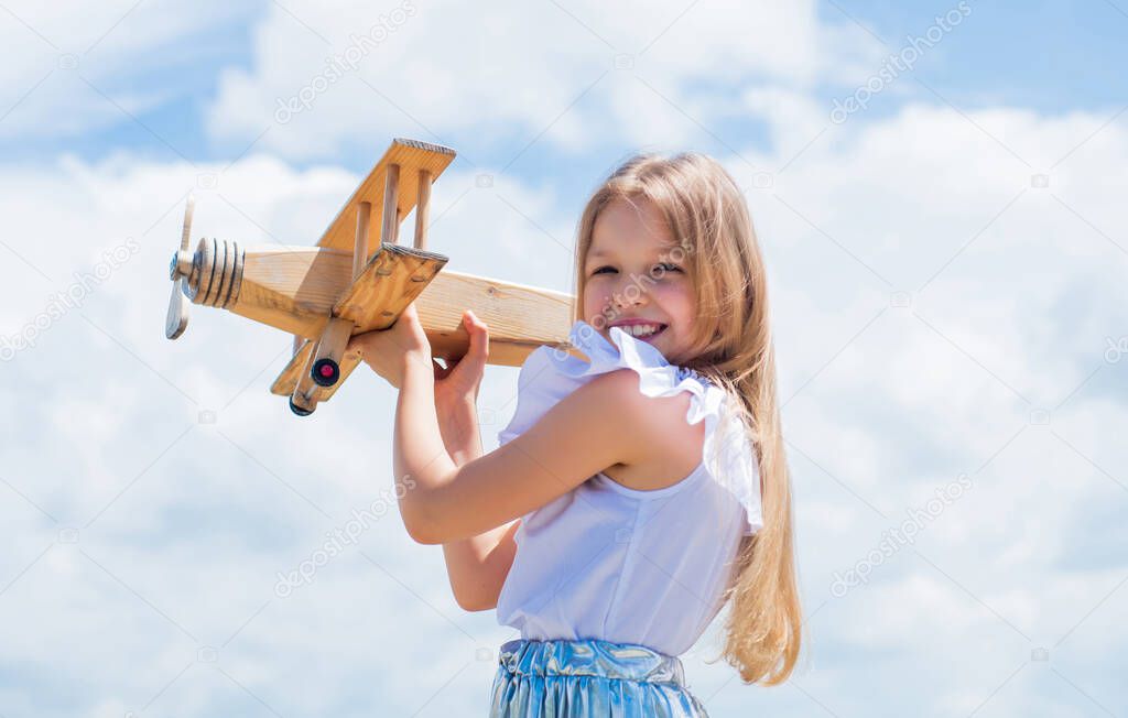cute kid hold wooden toy plane, travelling