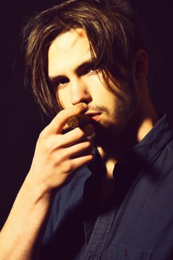 Ciddi sakallı adam puro içiyor.