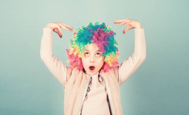 Çocuklar için oyunculuk okulu. Oyunculuk yeteneğini kariyere dönüştür. Sanatçı kız oyunculuk eğitimi alıyor. Çocuk renkli kıvırcık peruk yapay saç palyaço tarzı mavi arka plan. Sirk okulu konsepti