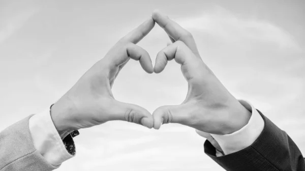 Kéz szív gesztus formák alakja segítségével ujjak. Kezek össze a szív alakú kék ég háttérben. Szerelmi szimbólum koncepció. Férfi kéz a szív alakú gesztus szimbóluma szerelem és romantika — Stock Fotó