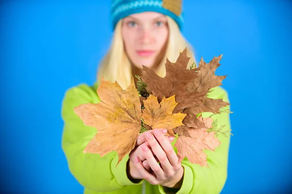 Skincare and beauty tips. Skincare routine for autumn. Enjoy autumn season. Autumn skincare tips. Bright moment. Active leisure and rest autumn season. Woman wear knitted hat hold fallen leaves