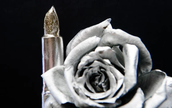 Metallisch silberne Farbe. Metallblume und Lippenstift. Schmieden und Skulptur. Silbermetall. Silberne Mode. Kosmetik und Schönheitsmittel. Lippenbalsam und Lippenstift. Makeup-Konzept. Modeschminke — Stockfoto