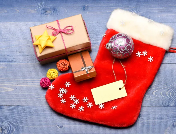 Vánoční pytel ve tvaru ponožky. Udržujte rodinné tradice. Nápad se zásobami. Zásobování vánoční dárkovou krabicí. Vánoční ponožky tónované dřevo pozadí horní pohled. Tradiční vánoční atribut — Stock fotografie