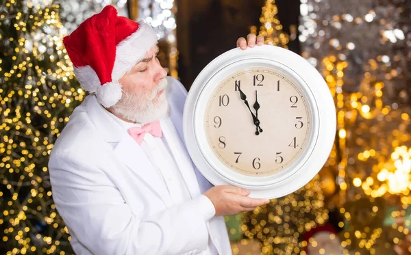 Weihnachtsmann hält Wecker. Silvester Mitternacht. Zeit zum Feiern. Es ist kurz vor Mitternacht. Zeit, Winterurlaub zu feiern. Beeilen Sie sich. Der Weihnachts-Countdown läuft. Warten auf Weihnachtsgeschenke — Stockfoto