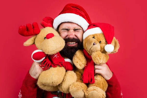 사랑은 공기중에 있다. 즐거운 크리스마스되 세요. 크리스마스 쇼핑 시간이야. 선물과 선물을 준비하 십시오. 순록과 곰 장난감. 산타 클로스 모자쓴 행복 한 수염 남자. 새해 파티. 축일을 기념하라 — 스톡 사진