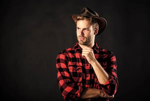 Archetypal image of Americans abroad. Cowboy life came to be highly romanticized. Man unshaven cowboy black background. Masculinity and brutality concept. Adopt cowboy mannerisms as a fashion pose