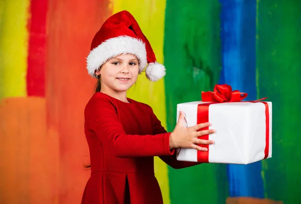 Wesołych Świąt i wesołych świąt. Mała dziewczynka trzyma pudełko z prezentami. Kid trzymać pudełko kolorowe tło. Zakupy świąteczne. Rodzinna tradycja. Zimowe wakacje. Piękny prezent. Oddawaj. — Zdjęcie stockowe