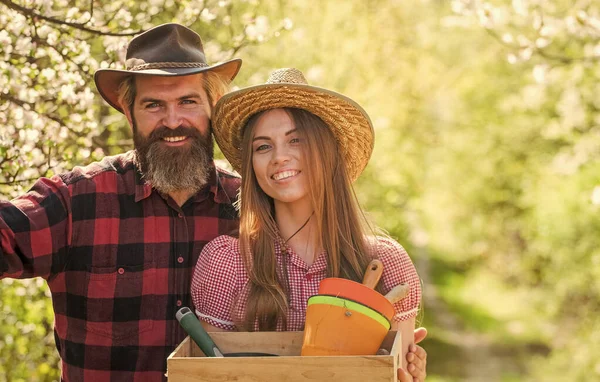 Farming couple. Happy couple hold gardeners tools. Family couple smile in spring garden. Couple in love in rural style. Hobby farm. Farming and gardening — Stock Photo, Image