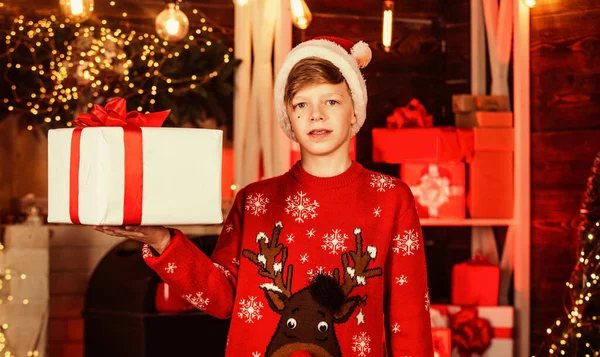 Хо-хо-хо. він має різдвяний подарунок. найкращі зимові канікули. щасливий підліток святкує новорічну вечірку. маленький хлопчик в червоному светрі для оленів. дитина в капелюсі Санта Клауса розважається вдома. веселого Різдва всі — стокове фото