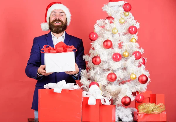 Gifts shop. Winter holidays. Boxing day. Christmas party. Sharing kindness and happiness. Prepare gifts for everyone. Man bearded hipster formal suit christmas tree hold gift box. Christmas gifts