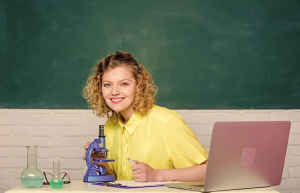 Schoolonderwijs. meisje in klaslokaal laboratorium met computer. aantekeningen maken over chemische onderzoeksresultaten. wetenschapper op school lab. biologie experimenteel onderzoek. student met microscoop en beker — Stockfoto