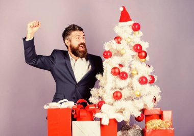 Noel hazırlığı ve kutlaması. Sakallı hippi adam Noel ağacının yanında resmi takım elbise giyer. Noel hediyeleri ve dekorasyonlar. Harika bir ofis noel partisi nasıl düzenlenir. Kutlamaya hazır.