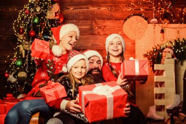 Değerli şeyler burada. Ailesi olan küçük kız kardeşler. Neşeli anne çocukları sever. Mutlu aile yeni yılı ve Noel 'i kutlar. Xmas hediyesini aç. Noel Baba 'dan hediyeler. Baba süslemeli ağaçta