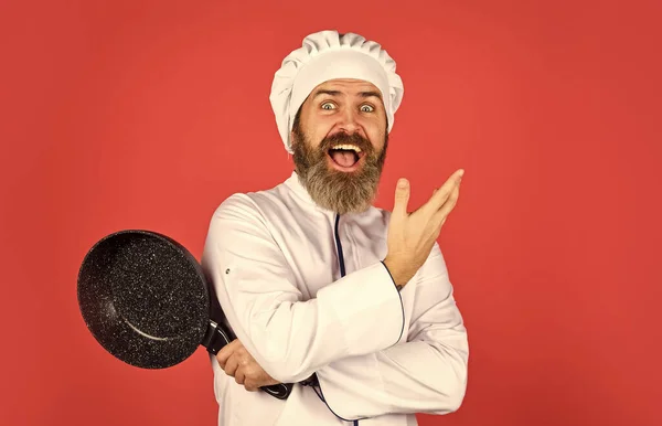 Бородатий кухар у формі Чоловік тримає сковороду. Готувати як професіонал. Легкі дешеві смачні страви, приготовані вдома. Будьте обережні. Готуємо їжу на кухні. Концепція приготування їжі. Високоякісна сковорода — стокове фото