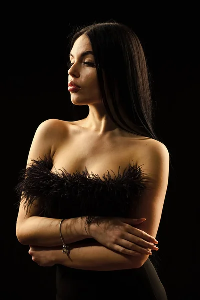 Retrato de jovem mulher elegante em vestido elegante preto. cuidados com a pele e maquiagem. Belo vestido preto. Jovem mulher bonita usar vestido de noite preto. menina com ombros nus posando sobre fundo preto — Fotografia de Stock