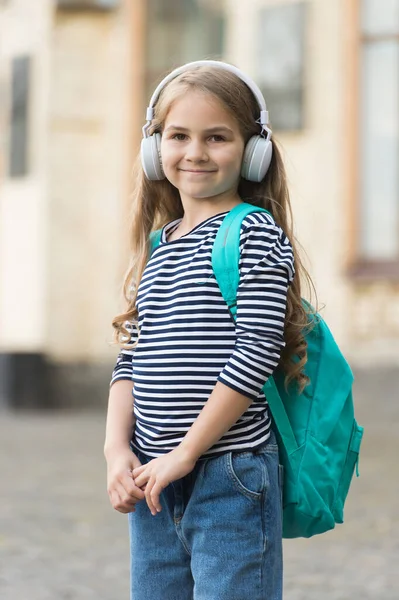 Buon bambino portare borsa da viaggio ascoltare musica in cuffie moderne indossando stile casual moda urbano all'aperto, stile di vita — Foto Stock