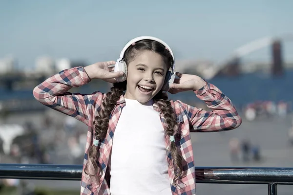 Ascolta gratis. Abbonati alla famiglia musicale. Accesso a milioni di canzoni. Goditi la musica ovunque. Migliori applicazioni musicali che meritano un ascolto. Ragazza bambino ascoltare musica all'aperto con cuffie moderne — Foto Stock