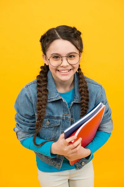Happy kid with nerd look hold school books in casual fashion style yellow background, back to school — Stock fotografie