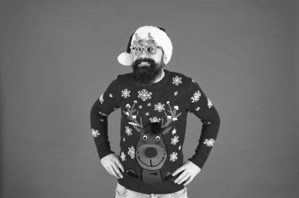 Giusto in tempo per Natale. divertente maglione a maglia hipster. vestiti caldi per il freddo. barbuto uomo Babbo Natale cappello sfondo rosso. Buon Natale a tutti. maschio in occhiali da festa di Natale. felice anno nuovo — Foto Stock