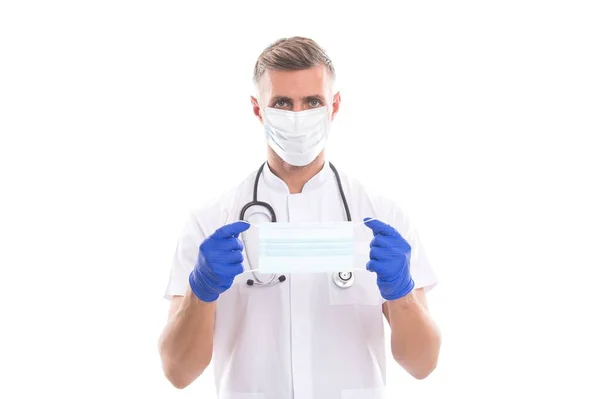 Solunum maskesi takan ve koronavirüs salgını sırasında ameliyat eldiveni takan steteskoplu erkek doktor terapisti. — Stok fotoğraf