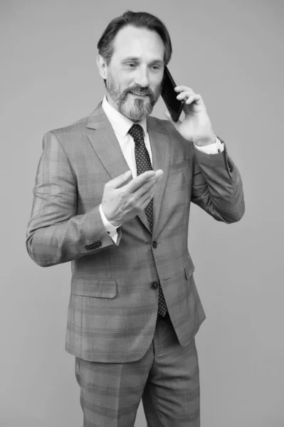 自信のある男性が携帯電話で話す。仕事中だ。誰かを助けようとして。オフィスジャケットの最高経営責任者(CEO)はスマートフォンを使う。成熟したビジネスマンの回答メール。正式なスーツを着たプロのビジネスマン — ストック写真