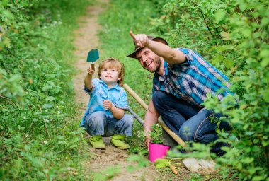 Bahçedeki küçük yardımcı. Çiftlik ailesi. Doğada yaşayan küçük bir çocuk ve baba. Bahçe aletleri. Bahar bahçıvanlığı rutini. Çiçek ekiyorum. Bahçıvanlık hobisi. Babası küçük oğluna bitkileri yetiştirmeyi öğretiyor.