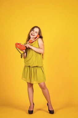 Yardımcı olabilir miyim? Küçük kız telefonda konuşuyor. Küçük çocuğun retro telefon konuşması var. İş görüşmesi. Arkadaşınla konuş. Modern yaşam iletişimi. Yeni teknoloji kavramı. Klasik aygıt modaName