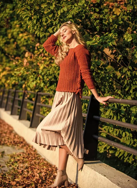autumn day. autumn woman outdoor. sunny day with fallen leaves. fall fashion season. female beauty. Femininity and tenderness. girl in corrugated skirt and sweater. Pleated trend. girl walk in park