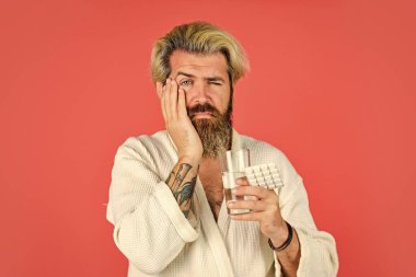 Dişim ağrıyor. Sakallı hippi yatakta rahatla. Yatak istirahatına ihtiyacı var. Akşamdan kalmanın sonuçları. Adam uykusuzluğa karşı hap alıyor. Korkunç bir baş ağrısı var. Erkek sağlığı ilacı. sağlıklı yaşam tarzı kavramı