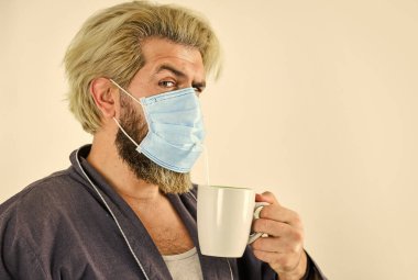 Tamamen korunuyor. Koronavirüsten korumak için maske takıyor. Maskeli adam pipetle çay içer. Hijyen konusunda ciddiymiş. Ağız ve burnu maskeyle örtün ve maske ile yüz arasında boşluk olmadığından emin olun.