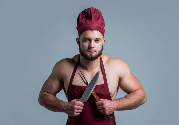 Athletic guy with strong muscles in chef apron cooking food, butchery — Stock Photo, Image