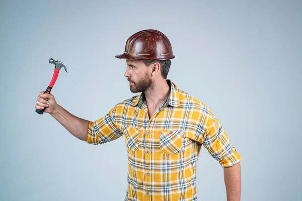 Reparaturen durchführen. Mann Architekt mit Hammer. Typen tragen Arbeiteruniform. schöner Bauarbeiter mit Helm. Älterer Mann trägt kariertes Hemd. professioneller Konstrukteur oder Mechaniker. Bauingenieur — Stockfoto