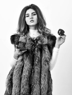 Seçkin kahve konsepti. Lüks aromanın ve sıcak kahvenin tadını çıkar. Güzel bayan küçük seramik fincan beyaz arka plan kahve içer. Lüks kürk giyen, sıcak kahve içen muhteşem bir kadın.