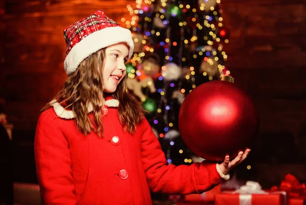 Decora todo a tu alrededor. Juguete brillante. Me encanta decorar el árbol de Navidad. Ambiente festivo el día de Navidad. Chica traje de Santa Claus celebrar grandes adornos árbol de navidad bola. Decoraciones de Navidad —  Fotos de Stock